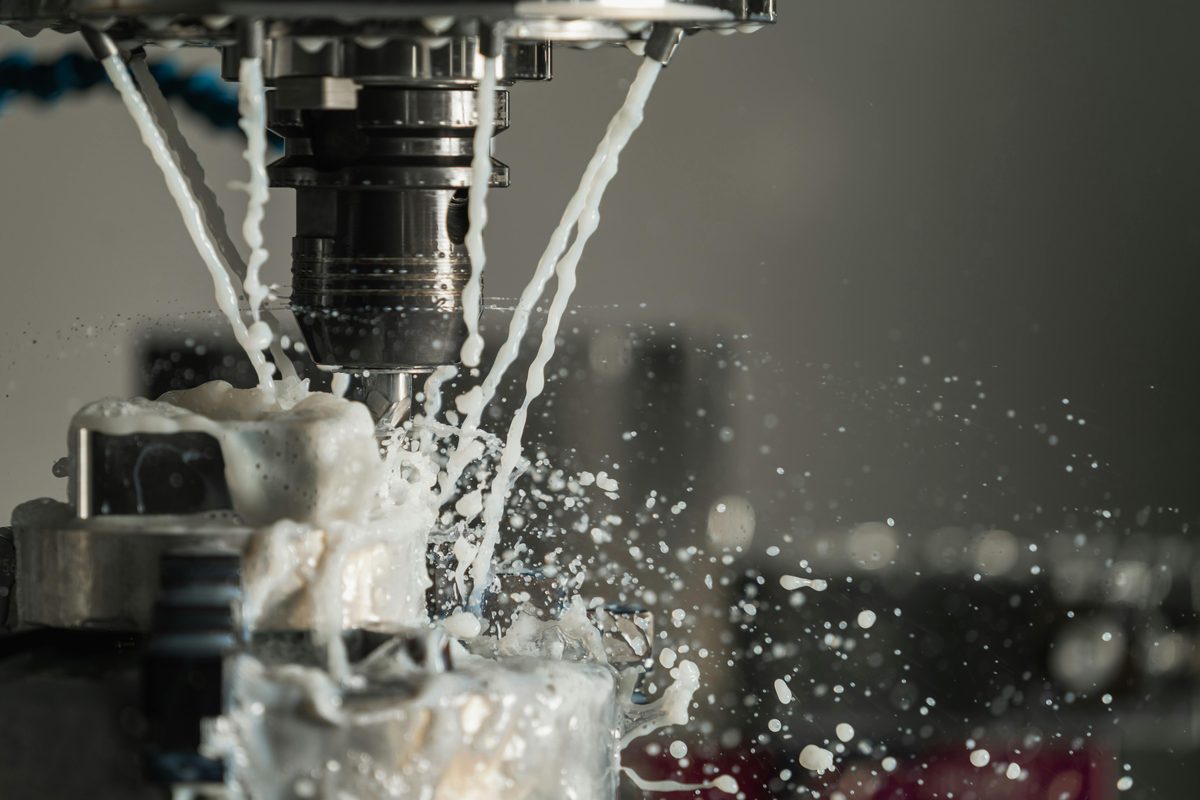 CNC milling machine with flood coolant in operation — Production-First IT for manufacturers in Menomonee Falls